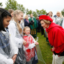 Dronningen hilser på Enya Aurora Hansen (6 år) og koret Lahko Voices på hagefesten. Foto: Lise Åserud, NTB scanpix.